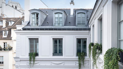 The facade of the Maison Colbert hotel. One of the towers of Notre Dame can be seen in the background.