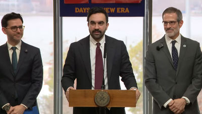 New York City mayor Zohran Mamdani (center) announcing the city's new regulations requiring hotel fee transparency.