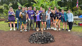 A group of students on the Imu Mea Ai tour complete building an imu, a traditional Hawaiian underground oven.